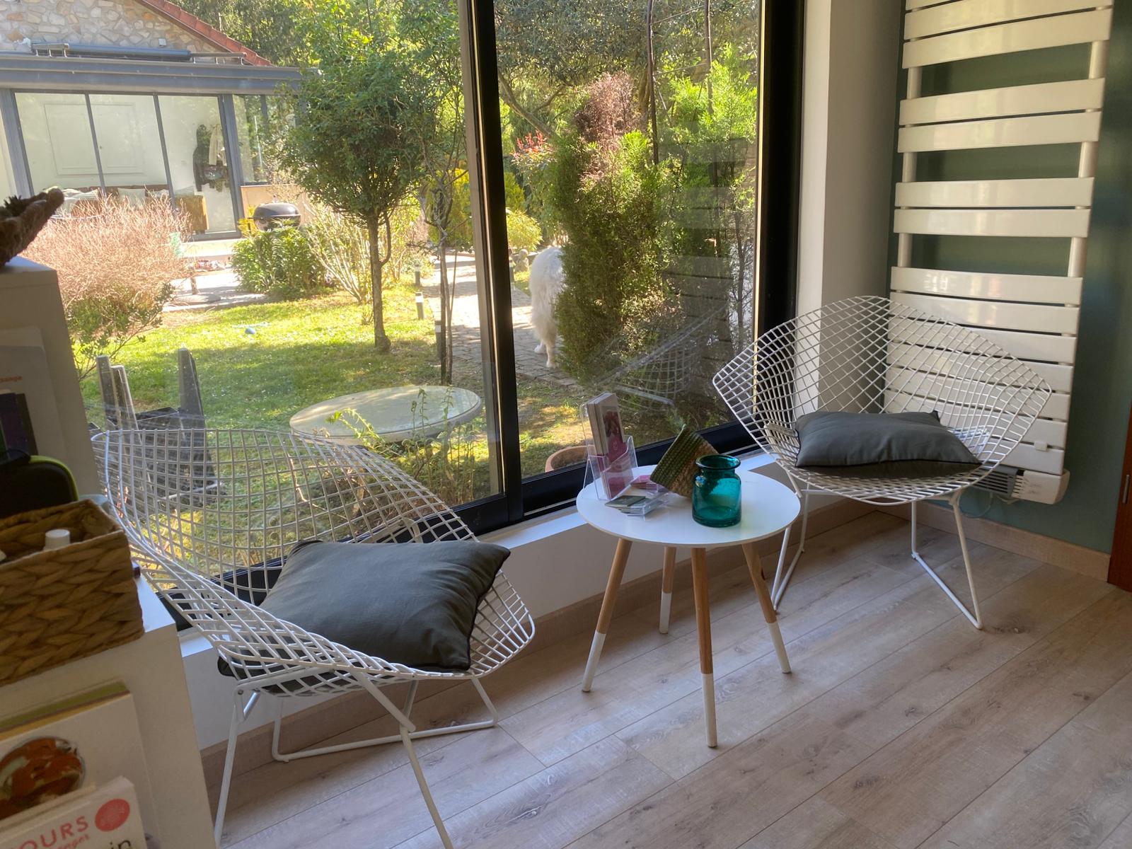 Salon d'attente du cabinet Sangaia - fauteuils fil blanc avec vue sur le jardin